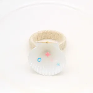Natural white seashell napkin ring with twine wrap, perfect for hotel table decor detail.