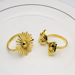 Gold metal napkin rings featuring elegant sunburst and bow designs, perfect for hotel table decor.
