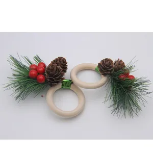 Christmas wooden napkin rings with pine needles and red berries for holiday table decor.