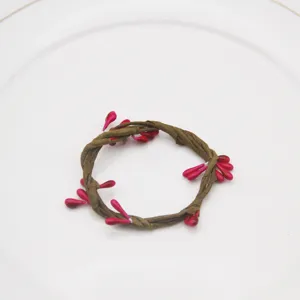 Handmade braided vine napkin ring with pink berries for table setting and party decoration.