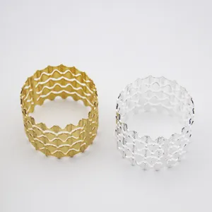 Set of two hollow metal napkin rings in gold and silver, elegant table decor for hotels.