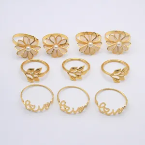 Gold metal napkin rings detail showing flower, leaf and love designs for table decor.
