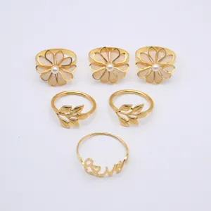 Gold metal napkin ring set of six featuring flower leaf and love designs for dining table.