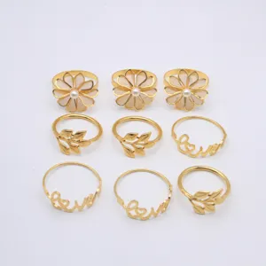 Gold metal napkin rings set featuring floral pearl, leaf and love designs for table decor.