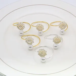Detail view of creative pearl flower napkin rings, elegant table decor in gold and silver.