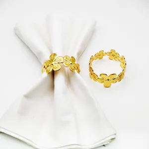 Gold metal flower napkin ring detail, elegant table decor accessory for hotel and dining.
