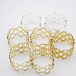 Gold and silver metal napkin rings with hollow diamond lattice design for table setting.
