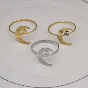 Close-up of alloy napkin rings featuring crescent moon and lantern design in gold and silver.