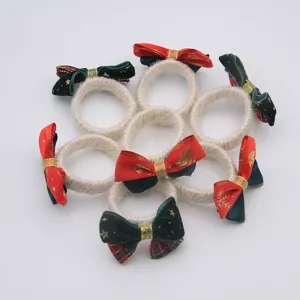 Handmade Christmas linen napkin rings with red and green bows, perfect for holiday table decor.