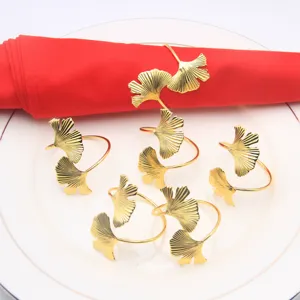 Gold ginkgo leaf napkin ring detail view, elegant metal table decor for hotel wedding dinner.