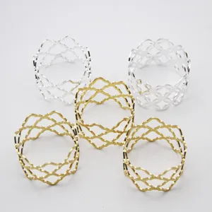 Detailed shot of gold and silver metal mesh napkin rings, elegant table decor accessories.