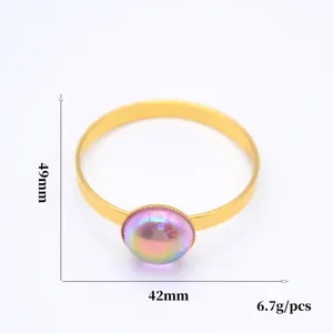 Gold metal napkin ring with colorful iridescent stone, elegant table decor for hotel dining.