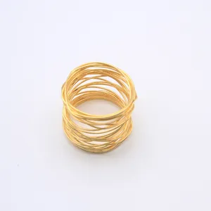Detail shot of gold wire coil napkin ring, modern metal table decor accessory for dining setup.
