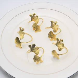 Set of gold metal ginkgo leaf napkin rings, elegant table decor for weddings and hotels.