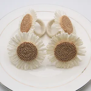Vista detallada de servilleteros de girasol tejidos en paja para una elegante decoración.