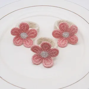 Handmade crochet flower napkin ring detail, pink floral table decor accent for dining table.