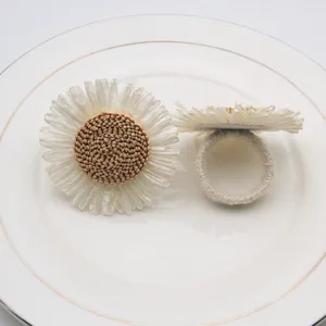 Servilletero de girasol tejido de paja para la decoración de la mesa del hotel.