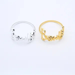 Close-up detail of stylish metal cursive letter napkin rings in gold and silver finish.