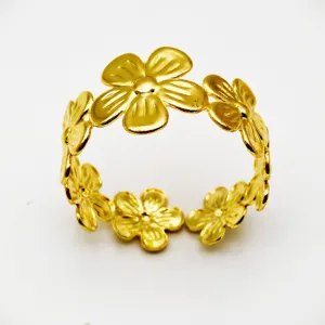 Gold metal flower napkin ring detail, elegant floral table decor for weddings and hotels.