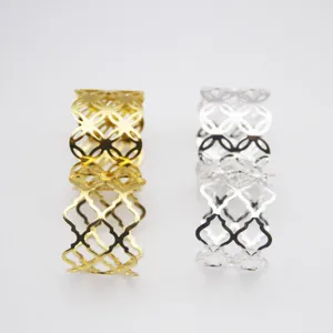 Metal napkin rings set in gold and silver colors with hollow quatrefoil lattice design for table decor.