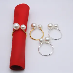 Detail view of elegant double faux pearl napkin rings in gold and silver, perfect for table decor.