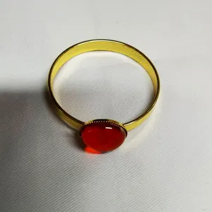 Gold metal napkin ring detail featuring a vibrant red gemstone accent for table decor.