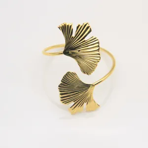 Elegant gold metal ginkgo leaf napkin ring for wedding table decor and hotel dining setup.