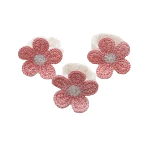 Handmade crochet five-petal flower napkin rings, elegant fabric table decor for hotel dining.