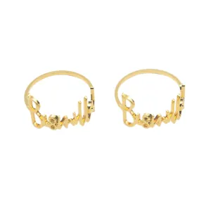 Gold metal cursive letter napkin rings for elegant table decor, wedding party dinner setup.