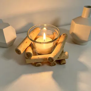 Wooden candle holder with glass cup and lit candle, rustic home desktop decor detail.
