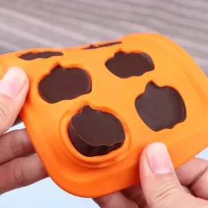 Dettaglio stampo zucca in silicone flessibile che mostra cioccolato da forno.