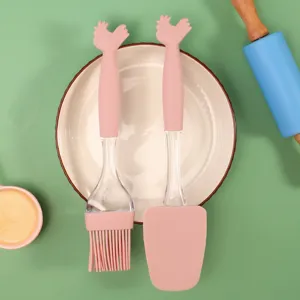 Set di utensili da cucina in silicone rosa con pennello e spatola dal design con testa di gallina.