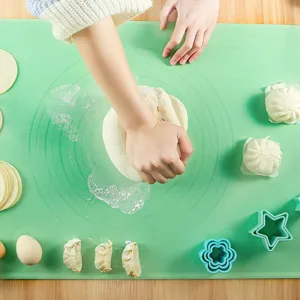 Tappetino per impastare in silicone verde con chiare scale di misura per dolci e pane.