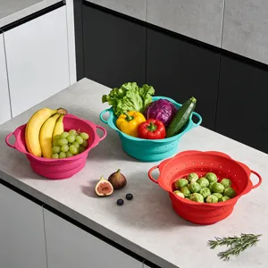 Detailed view of collapsible silicone kitchen colanders in multi colors filled with fresh fruits.