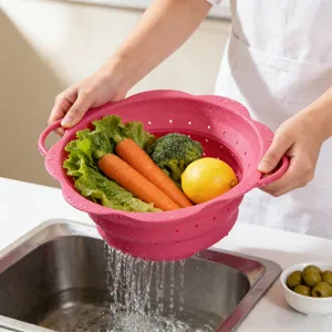 Detail shot of collapsible pink silicone colander draining fresh vegetables in kitchen sink.