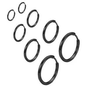 Primo piano dettagliato di orecchini a cerchio minimalisti in acciaio inossidabile nero.