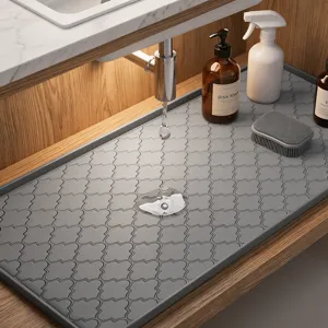 Nahaufnahme des grauen Silikon-Spülmatten-Details unter dem Wasserhahn, rutschfestes Design.