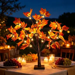 Detail view of the glowing LED maple tree light creating a cozy autumn party ambiance.