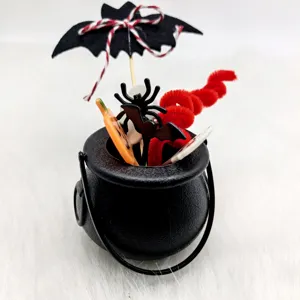 Close-up detail of Halloween mini black cauldron with bat and spider decor for party.