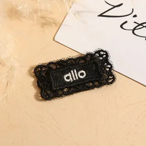 Black lace woven fabric patch label with white allo embroidery, ideal for DIY garment accessories.