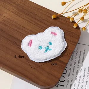 Close-up detail of the fluffy white bear embroidered patch, showing soft texture and stitching.