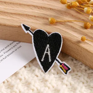 Écusson brodé en forme de cœur avec flèche et lettre A, ideal pour décoration de vêtements.