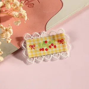 Detailed close-up of Korean cute cartoon lace fabric patch with embroidered cherries and bows.