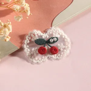 Close-up of cute cherry lace embroidery patch, exquisite details for DIY craft decoration.