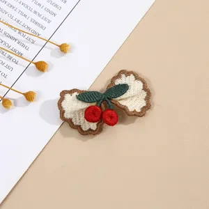 Cherry bow embroidery patch detail shot, cute fabric craft accessory for clothing and craft decor.