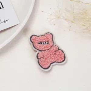 Pink fluffy bear embroidered patch close up, cute plush clothing DIY accessory detail view