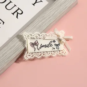 Cute lace embroidered patch with sweet bow and smile design, perfect for DIY clothing decor.