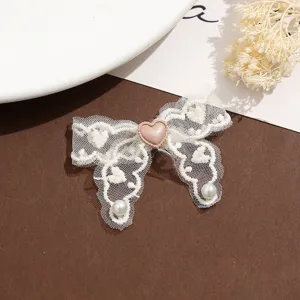 Détails du patch nœud en dentelle blanche avec cœur rose et perles pour loisirs créatifs et couture.
