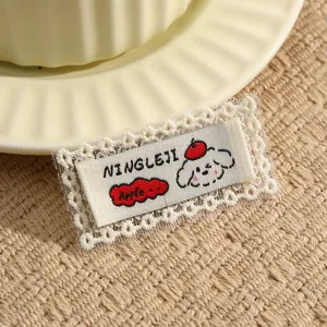 Detailed view of DIY embroidered lace patch with cute puppy design for clothing decoration.