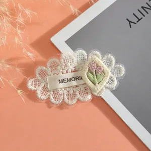 Lace embroidery patch detail showing exquisite floral pattern and woven label decoration.